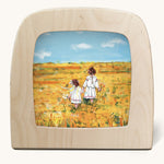 Toverlux Magic Lamp silhouette by artist Gwen van Knippenberg. A watercolour and pencil style illustration of two sisters in white dresses walking through a yellow barley field.