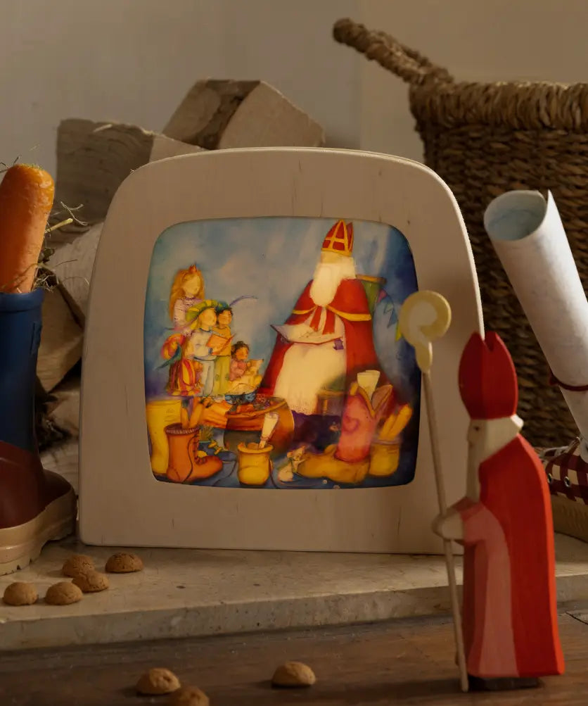 Toverlux layered light silhouette with Saint Nicholas Christmas artwork by Anne Illustrates displayed in a lit magic lamp with an Ostheimer father Christmas Waldorf figure placed in front.