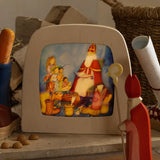 Toverlux layered light silhouette with Saint Nicholas Christmas artwork by Anne Illustrates displayed in a lit magic lamp with an Ostheimer father Christmas Waldorf figure placed in front.