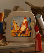 Toverlux layered light silhouette with Saint Nicholas Christmas artwork by Anne Illustrates displayed in a lit magic lamp with an Ostheimer father Christmas Waldorf figure placed in front.