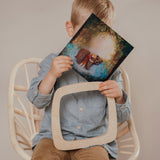 A child inserting a silhouette inside the  Toverlux Artisan Magic Window Frame available at Babipur. 