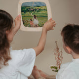 2 children looking at a silhouette inside a Toverlux Magic Window Frame available at Babipur. 