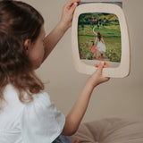 A child inserting a Toverlux silhouette inside the magic wooden frame available at Babipur.