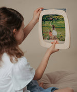 A child inserting a Toverlux silhouette inside the magic wooden frame available at Babipur.