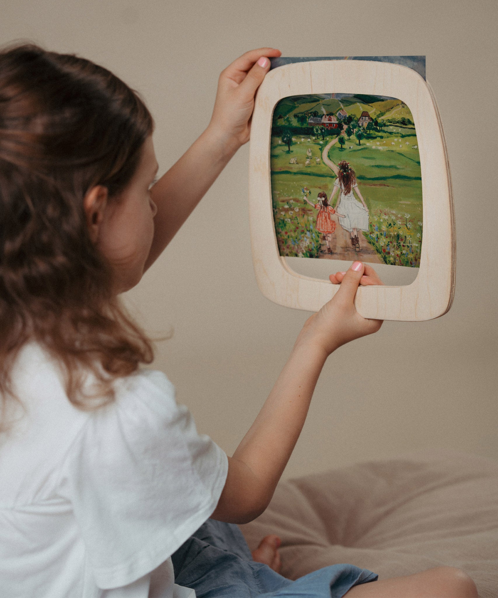 A child inserting a Toverlux silhouette inside the magic wooden frame available at Babipur.