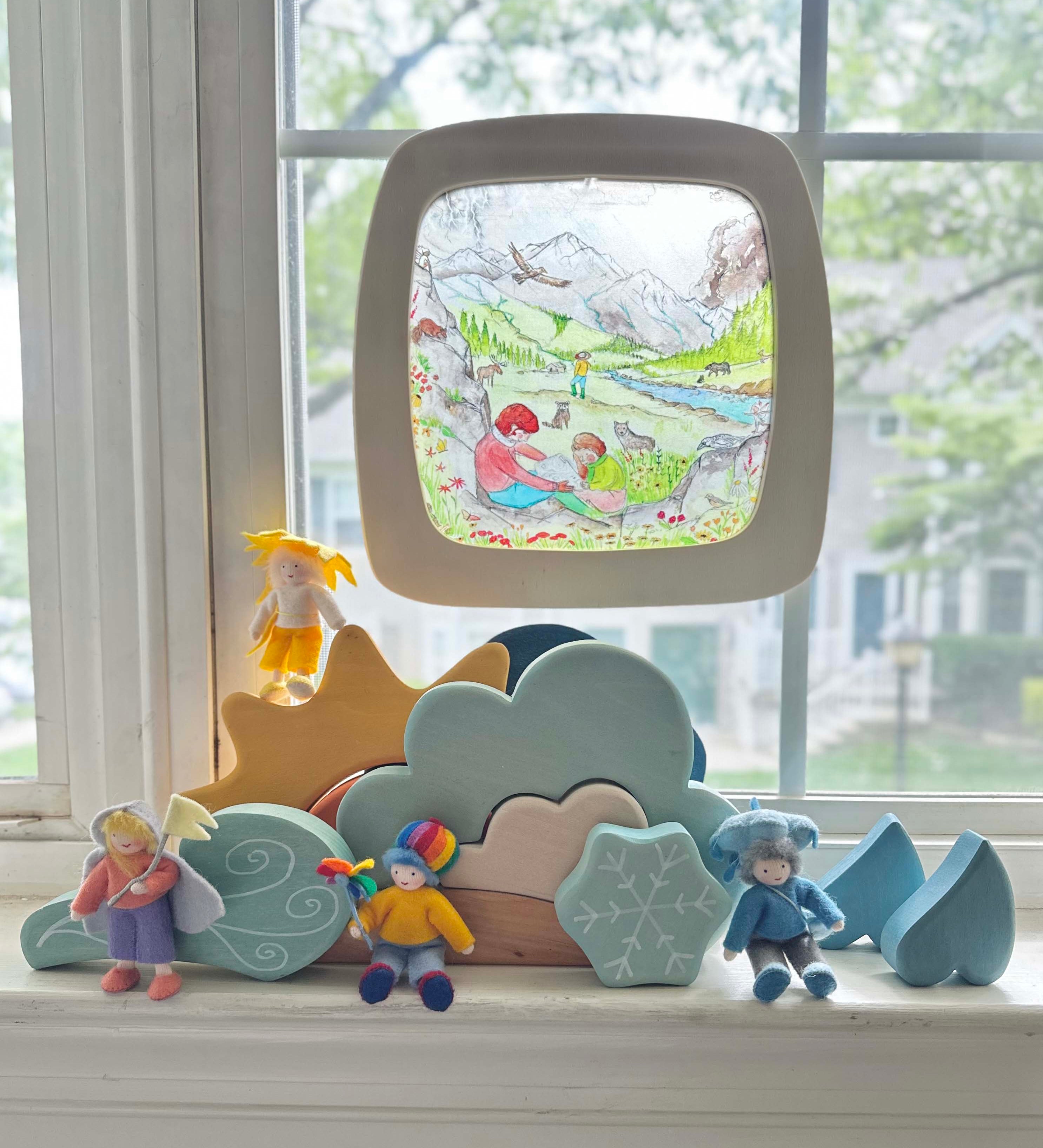 Toverlux Edulux watercycles silhouette featuring Stephanie Green's Mountain artwork shown in a wooden magic window frame. A Grimm's weather set has been set up on the windowsill underneath.
This silhouette is part of a wide range of Toverlux silhouettes available here at Babipur. 
