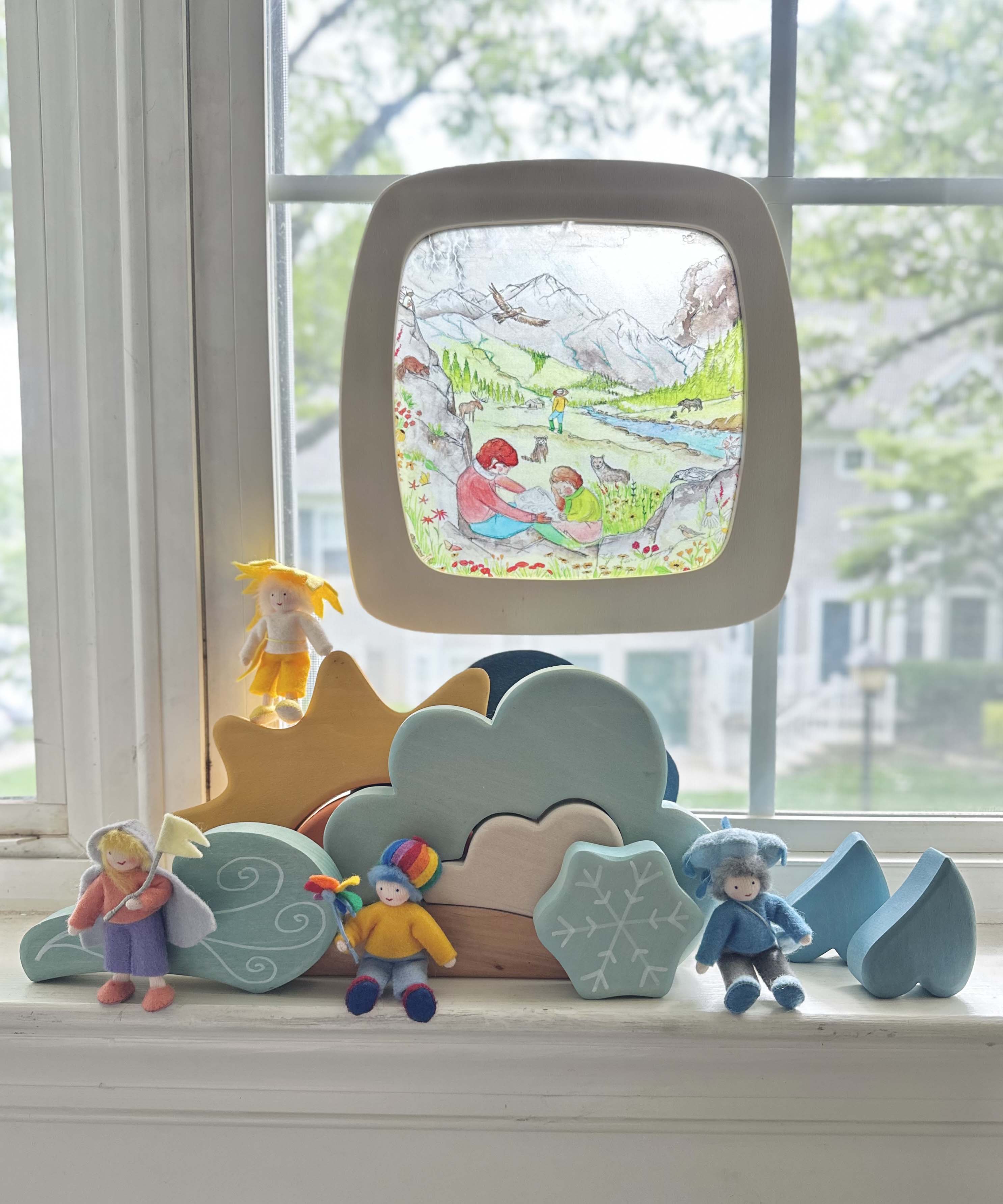 Toverlux Edulux watercycles silhouette featuring Stephanie Green's Mountain artwork shown in a wooden magic window frame. A Grimm's weather set has been set up on the windowsill underneath.
This silhouette is part of a wide range of Toverlux silhouettes available here at Babipur. 