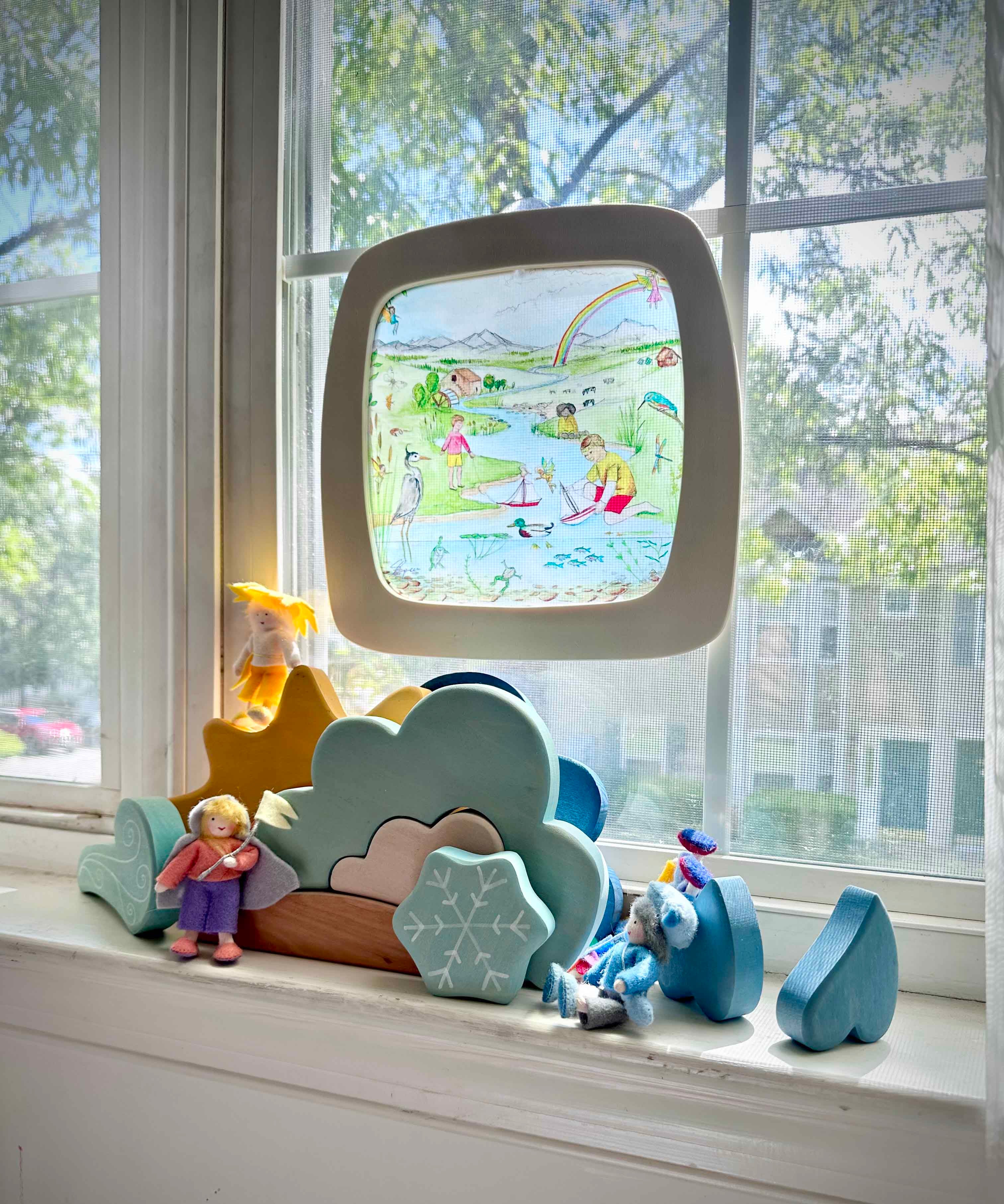 Toverlux Edulux watercycles silhouette featuring Stephanie Green's River artwork shown in a wooden magic window frame. A Grimm's weather set has been set up on the windowsill underneath.
This silhouette is part of a wide range of Toverlux silhouettes available here at Babipur. 