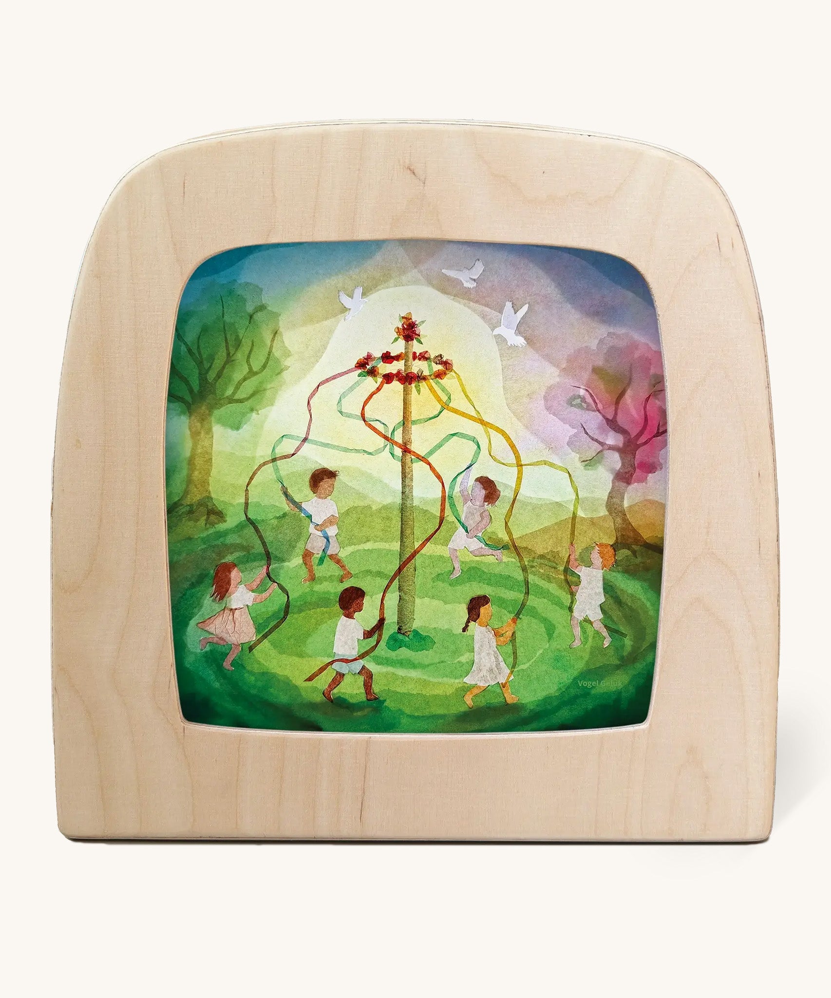 Toverlux magic lamp with a Easter ribbon dance silhouette by artist Vogel Geluk. A watercolour style illustration of children dancing around a pole with flowing ribbons in a green field.