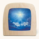 Toverlux guiding star winter silhouette by Baukje Exler. Blue illustration featuring a flock of sheep and a shepherd underneath a bright shining star. 