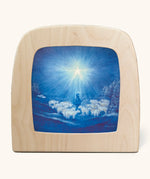 Toverlux guiding star winter silhouette by Baukje Exler. Blue illustration featuring a flock of sheep and a shepherd underneath a bright shining star. 