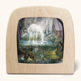 Toverlux silhouette artwork of a white unicorn drinking from a lake in a magical woodland scene with pixies, fairies, and toadstools.