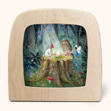 Toverlux silhouette artwork of a child, fairy and an owl taking part in a magical midsummer ritual forest scene on a tree stump with an egg placed in the middle. 