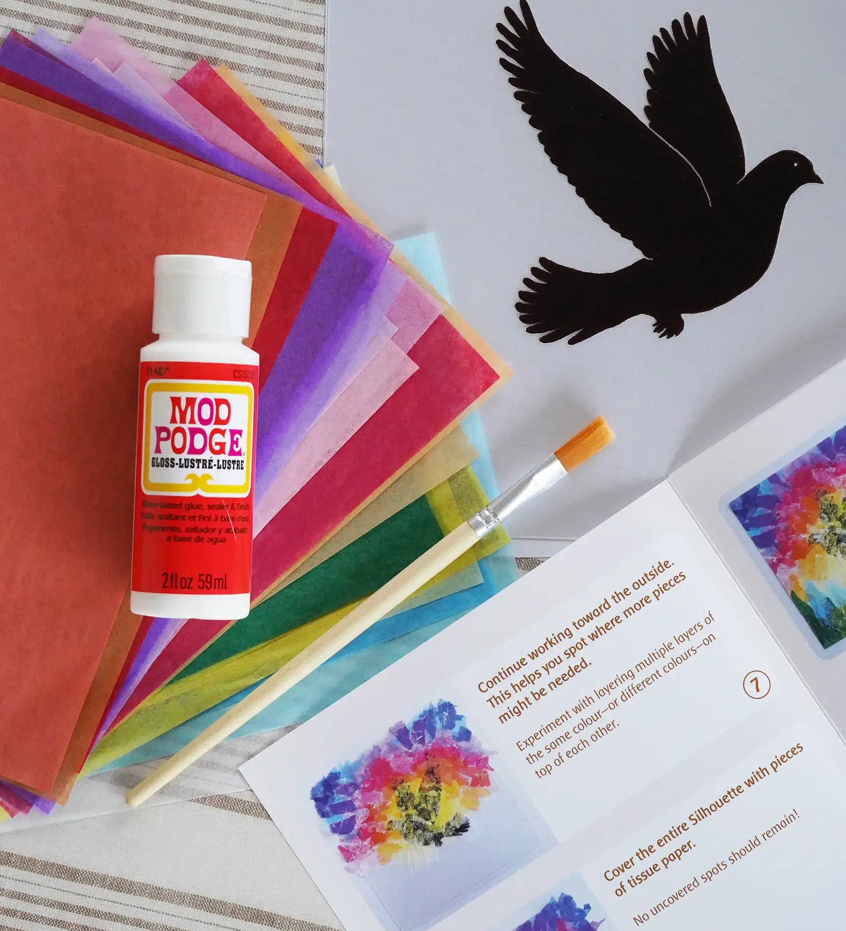 Toverlux Spring dove DIY silhouette transparency craft kit featuring a Vogel Geluk design. The kit includes silhouette panel with dove design, 20 sheets of coloured paper, paint brush, mod podge glue sealer and a step by step instruction guide.