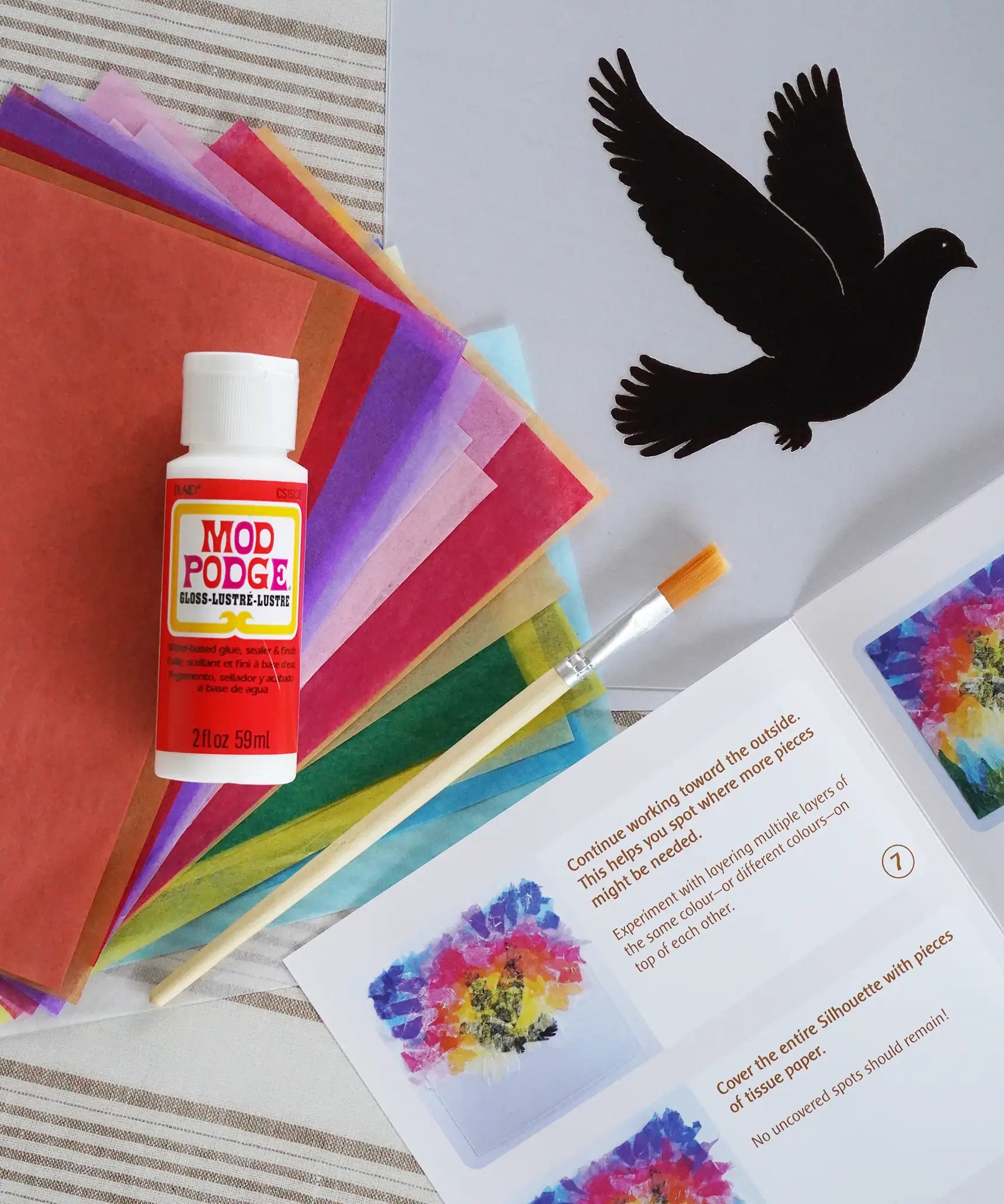 Toverlux Spring dove DIY silhouette transparency craft kit featuring a Vogel Geluk design. The kit includes silhouette panel with dove design, 20 sheets of coloured paper, paint brush, mod podge glue sealer and a step by step instruction guide.