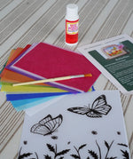 Contents of the Toverlux Summer butterflies DIY silhouette transparency craft kit featuring a Vogel Geluk design. The kit includes silhouette panel with dove design, 20 sheets of coloured paper, paint brush, mod podge glue sealer and a step by step instruction guide.