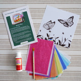 Contents of the Toverlux Summer butterflies DIY silhouette transparency craft kit featuring a Vogel Geluk design. The kit includes silhouette panel with dove design, 20 sheets of coloured paper, paint brush, mod podge glue sealer and a step by step instruction guide.