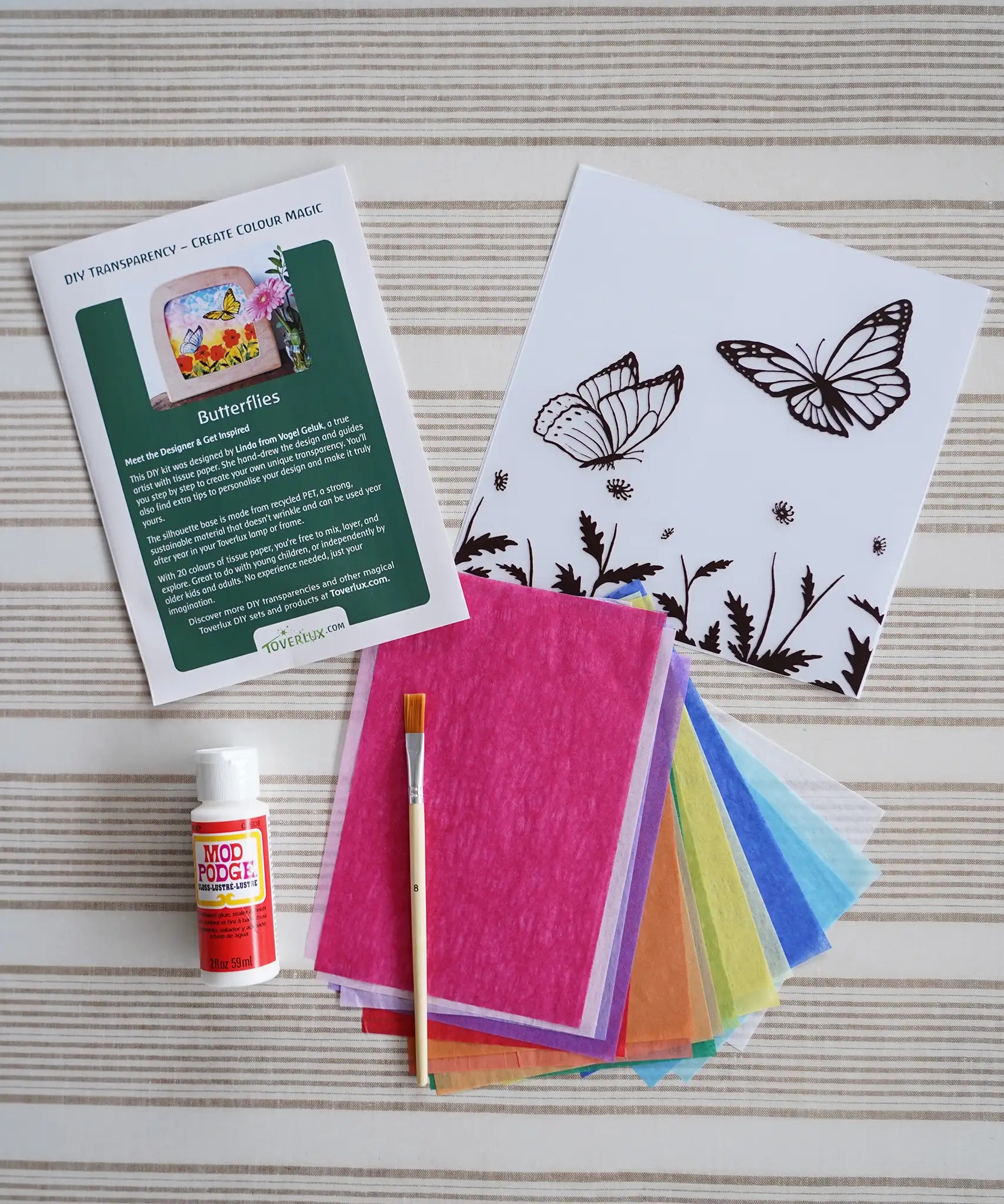 Contents of the Toverlux Summer butterflies DIY silhouette transparency craft kit featuring a Vogel Geluk design. The kit includes silhouette panel with dove design, 20 sheets of coloured paper, paint brush, mod podge glue sealer and a step by step instruction guide.
