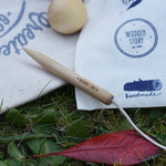 A close up of the wooden marker and string on the cotton storage bags. The smaller jack ball can be seen in the background. 