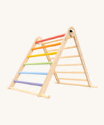 Triclimb folding wooden pikler climbing frame with pastel inspired coloured rungs on one side including purple, blue, green, yellow, orange, pink and natural unpainted rungs on the other side. Features longer natural coloured rungs on the bottom as a base. 
