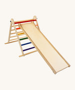 Triclimb wooden folding pikler climbing frame with rainbow themed rungs showing the second side Triclimb Miri slide hooked on a rung.