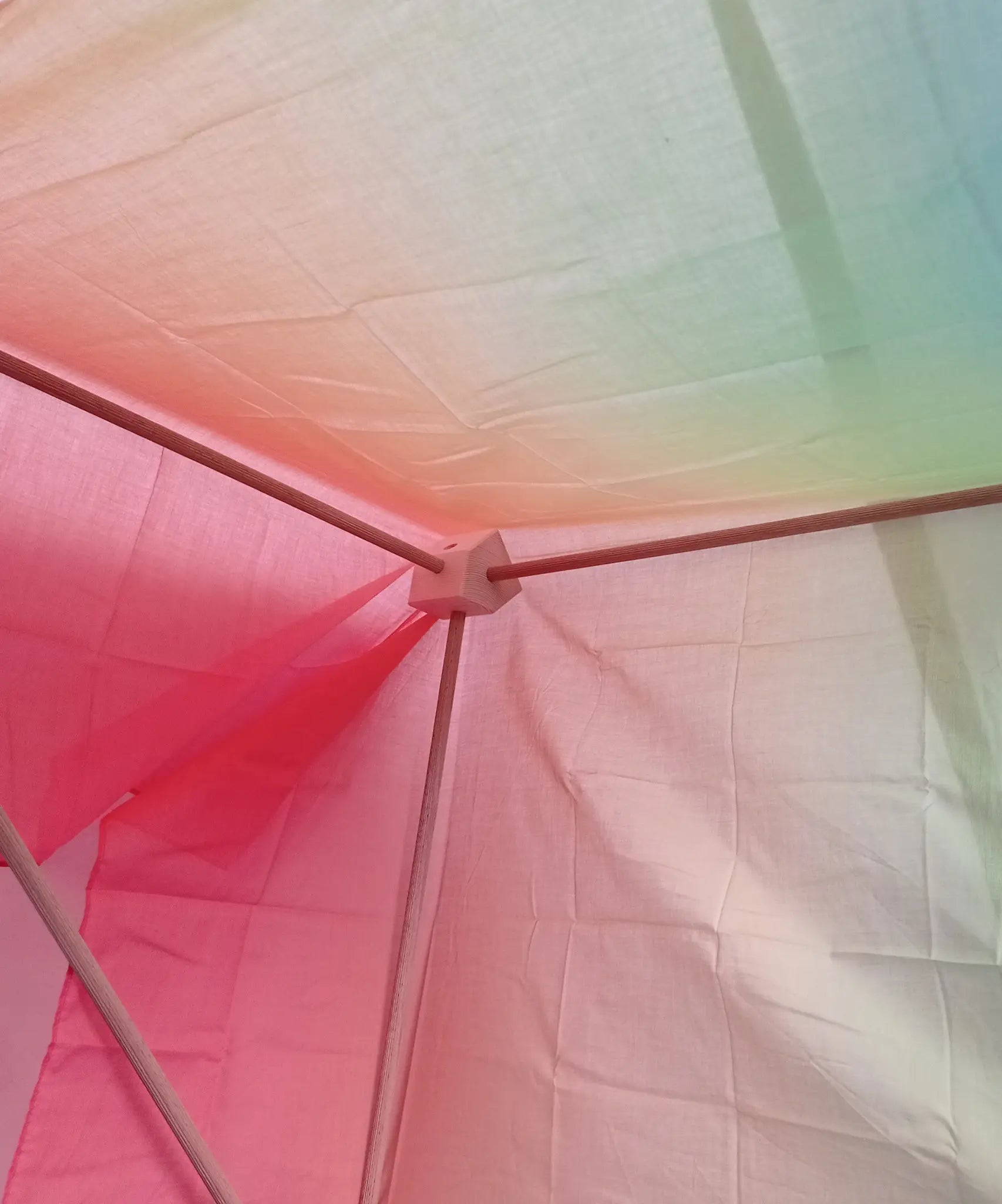 Inside of a tent build made from the Trigonos big start set showing the wooden corner block with frame poles and cloth on top