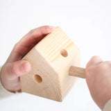 Child hand assembling a wooden Trigonos pole in a triangular corner corner block