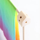 Wooden corner block from the Trigonos big start rainbow set with a rainbow cloth over a frame pole