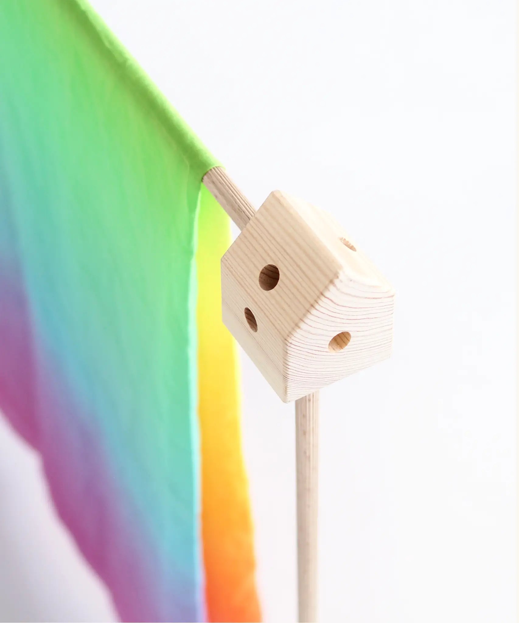 Wooden corner block from the Trigonos big start rainbow set with a rainbow cloth over a frame pole
