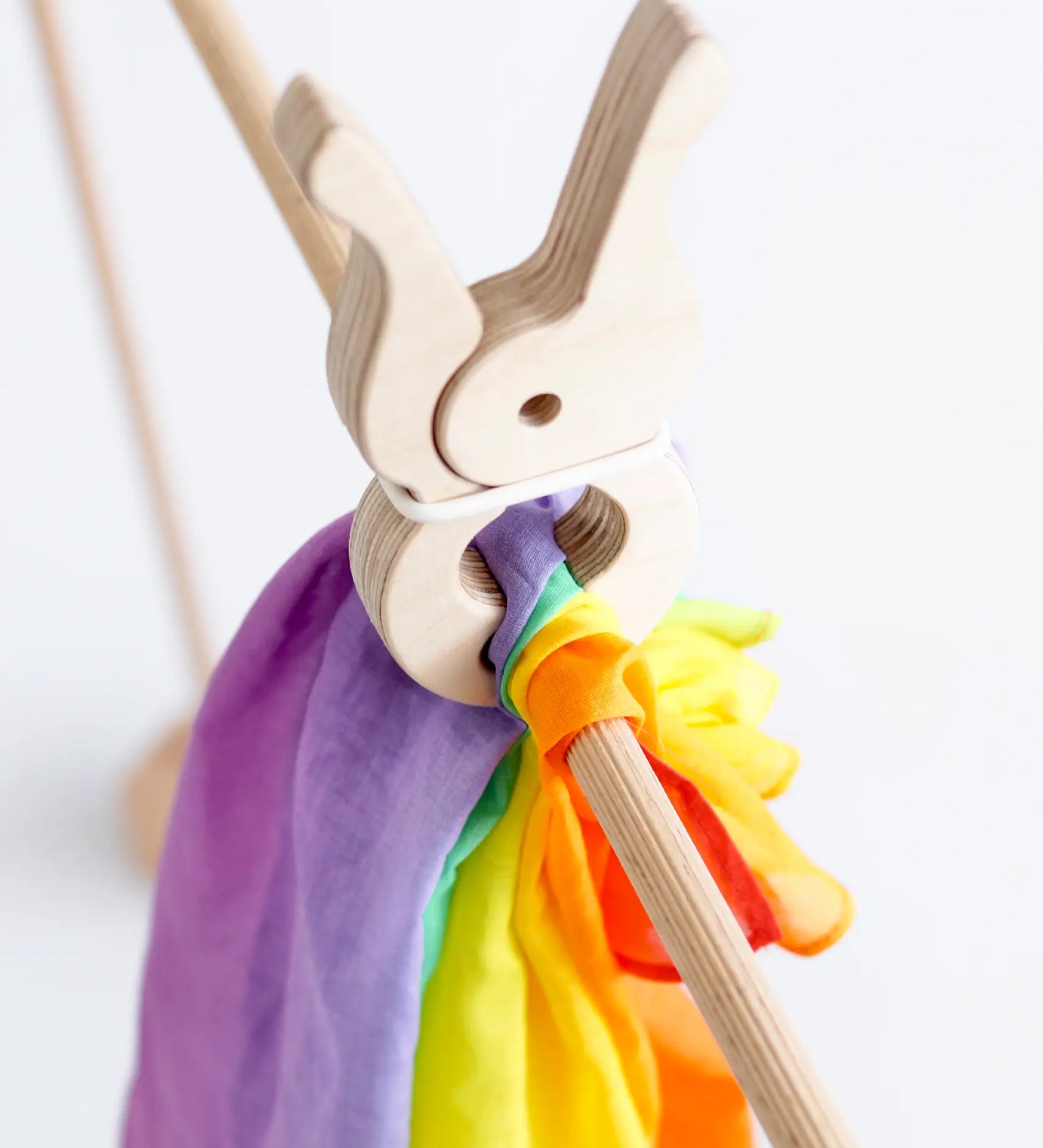 Rainbow cotton cloth from Trigonos big start held by a giant wooden peg on wooden frame pole