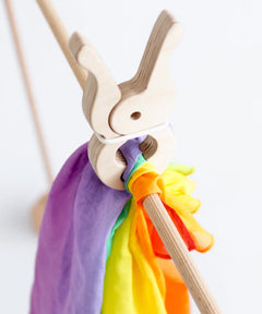 Rainbow cotton cloth from Trigonos big start held by a giant wooden peg on wooden frame pole