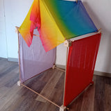 Simple tent build made from the wooden Trigonos big start set showing a rainbow cloth on the roof and coloured cloths on the side
