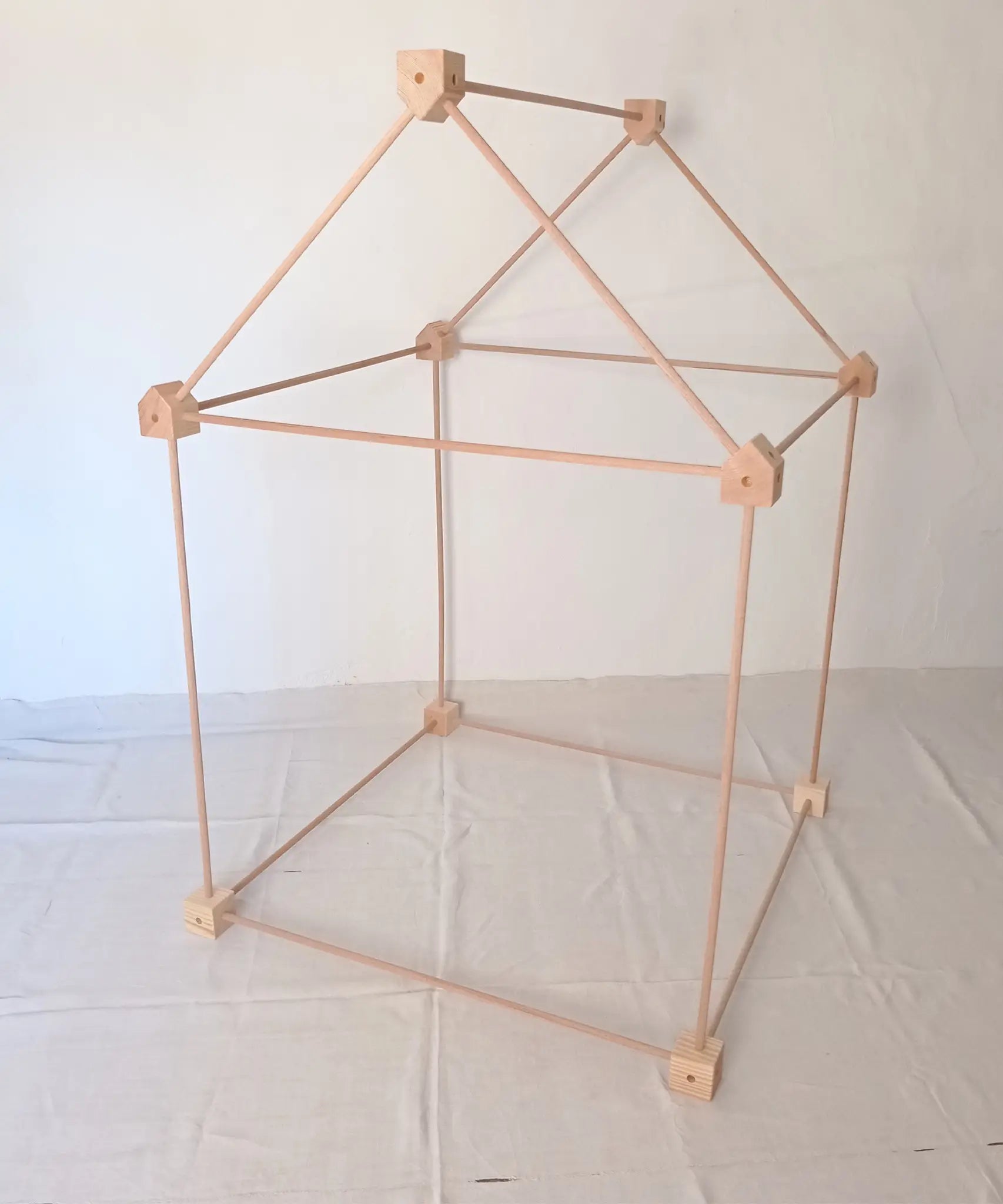 Trigonos big start set showing a tent made up from wooden poles and corner blocks 