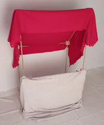 A market stall setup made from the Trigonos wooden big start set showing a red blanket on top of the frame. 