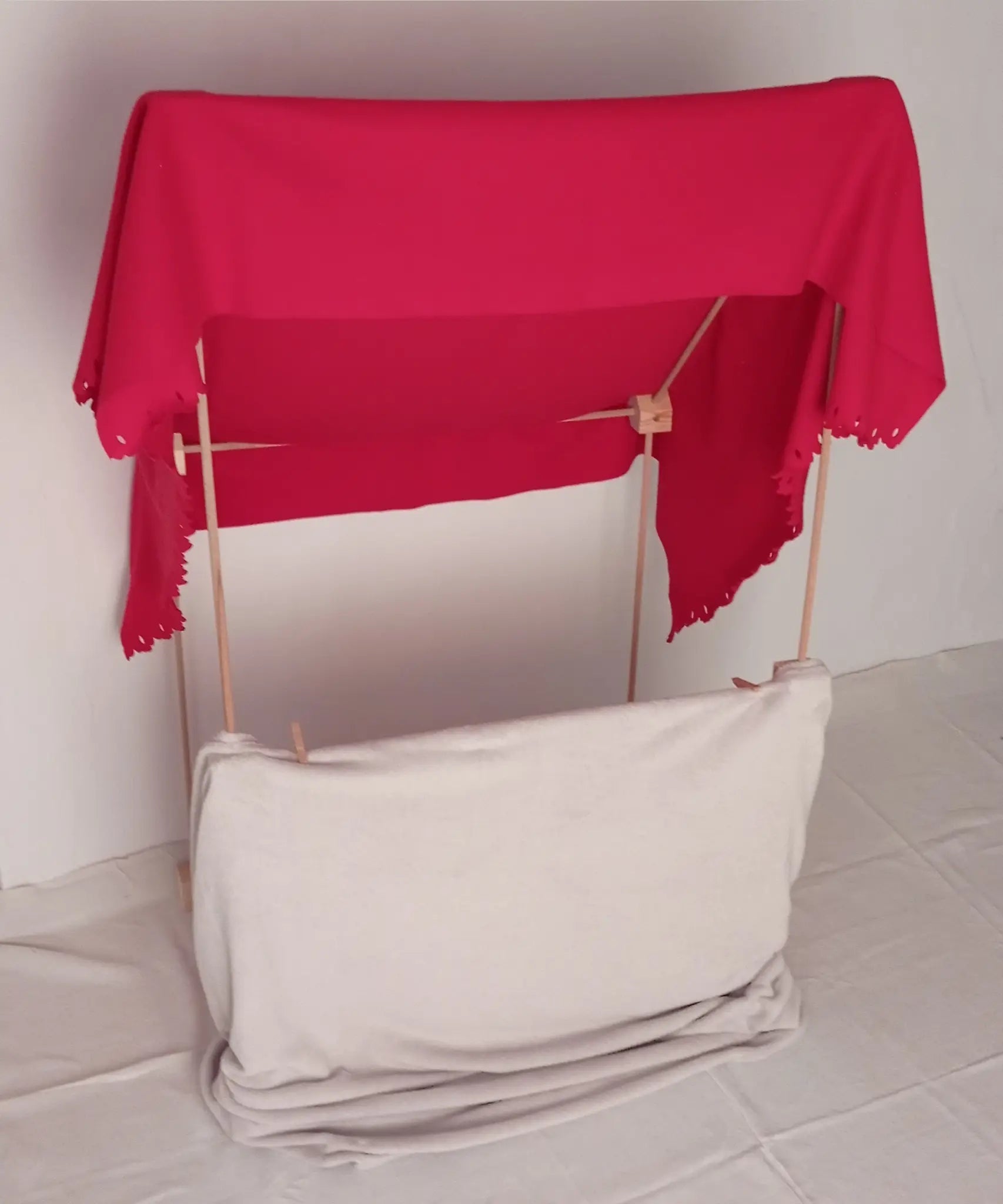 A market stall setup made from the Trigonos wooden big start set showing a red blanket on top of the frame. 
