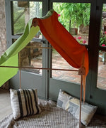A tent setup made from the Trigonos wooden big start set showing a rainbow cloth on top of the frame and cushions inside
