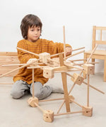 Child with a complex build using wooden pieces from the Trigonos starter ser