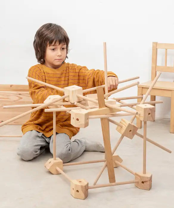 Child with a complex build using wooden pieces from the Trigonos starter ser