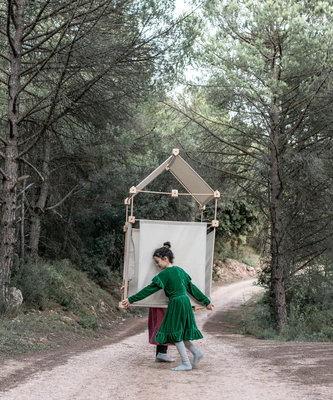 2 children carrying a den made from the Trigonos family wooden construction set