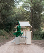 Child jumping in front of a den made from the Trigonos family wooden construction set in a forestry