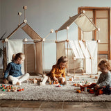 Multiple dens built from the Trigonos family wooden construction set with children playing with wooden toys 
