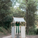 Child inside a den made from the Trigonos family wooden  construction set in a forestry