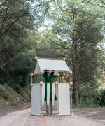 Child inside a den made from the Trigonos family wooden  construction set in a forestry