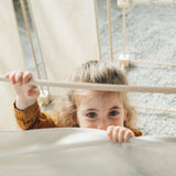 Child standing inside a tent made from the Trigonos kernel organic family constructions set