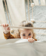 Child standing inside a tent made from the Trigonos kernel organic family constructions set