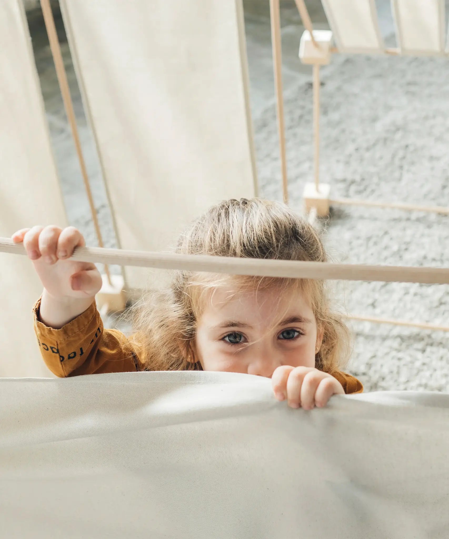Child standing inside a tent made from the Trigonos kernel organic family constructions set