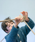 Child placing wooden poles into a corner block for the roof used from the Trigonos kernel organic set