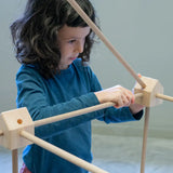 Child placing wooden poles into a corner block used from the Trigonos kernel organic set