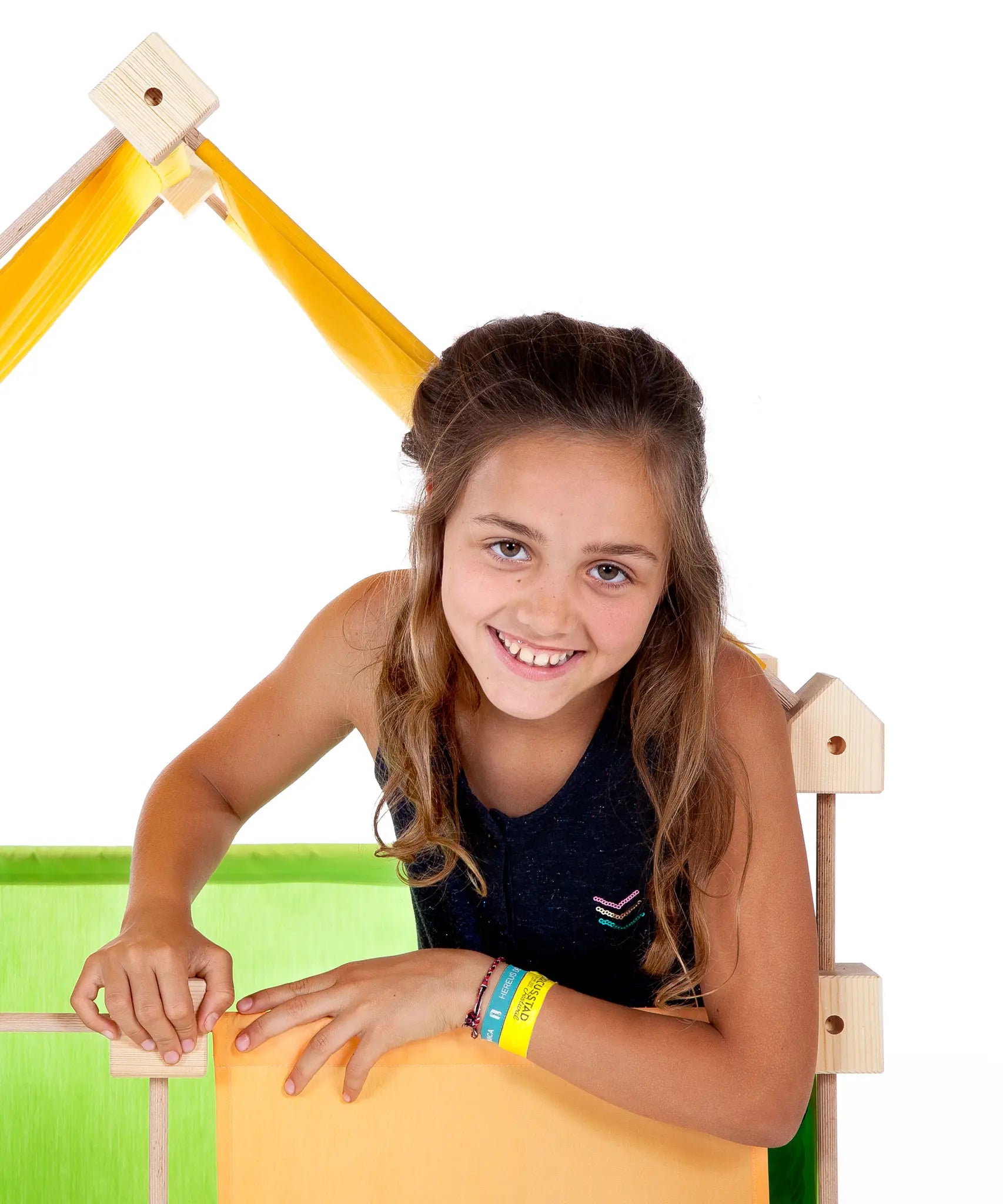 Child inside a tent structure made from the Trigonos maxi green wooden construction set
