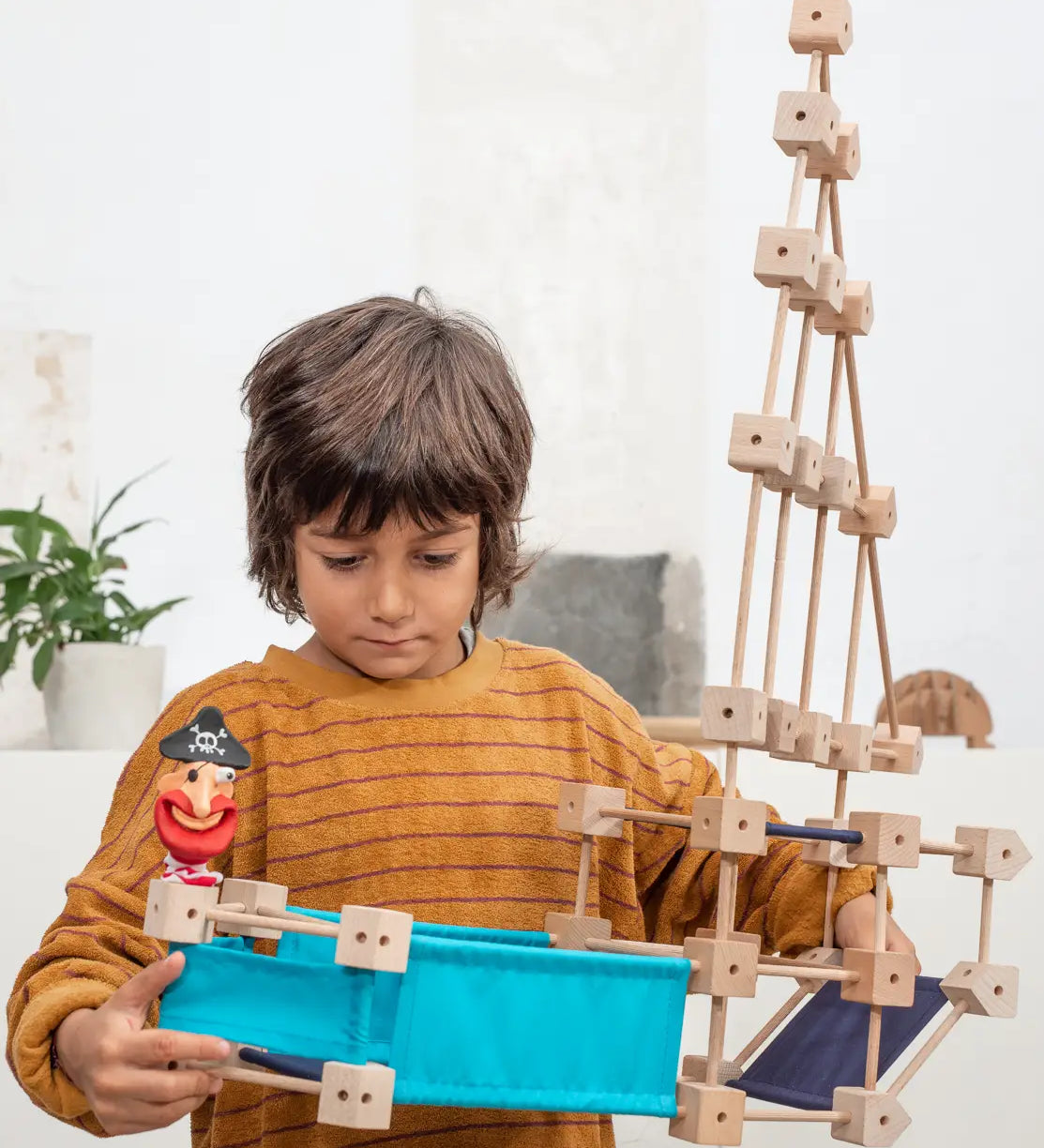 Child holding a pirate ship build made from piece out of the Trigonos mini medium construction kit 